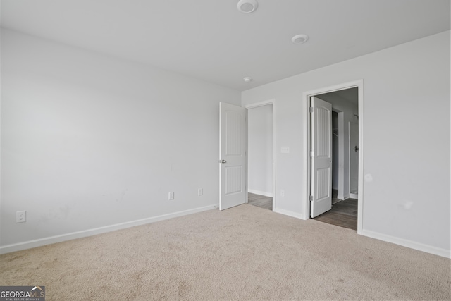unfurnished bedroom featuring baseboards and carpet