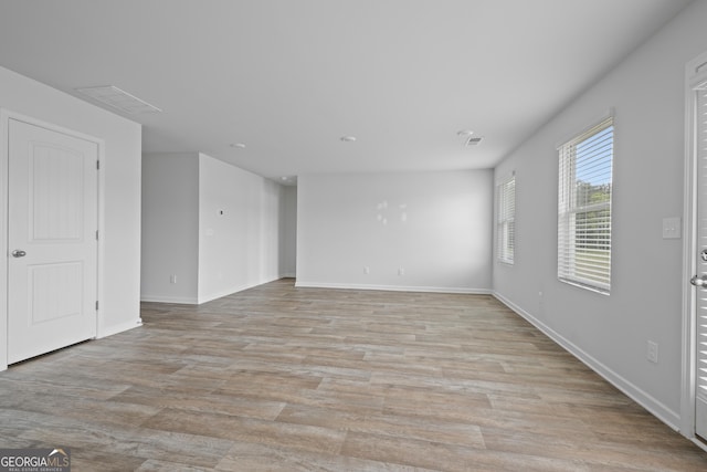 interior space featuring baseboards, light wood-style flooring, and visible vents