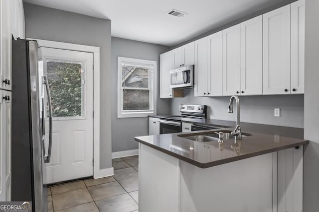 960 Byron Dr SW, Atlanta, GA 30310 - kitchen with dark countertops, a sink, stainless steel appliances, a peninsula, and visible vents