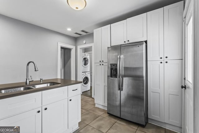 960 Byron Dr SW, Atlanta, GA 30310 - kitchen with light tile patterned flooring, stainless steel fridge, a sink, stacked washing maching and dryer, and white cabinetry