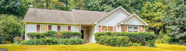 view of front facade with a front lawn and roof with shingles