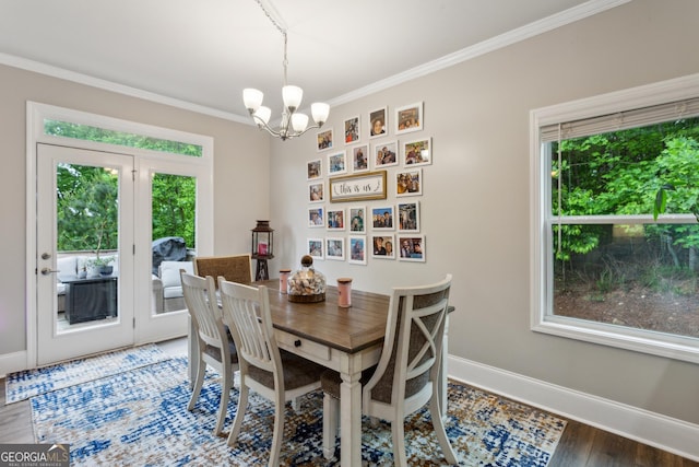 dining room featuring healthy amount of natural light, a chandelier, ornamental molding, baseboards, and wood finished floors