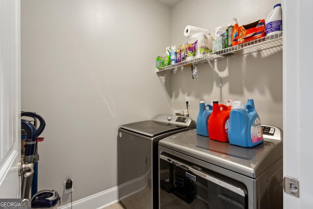 laundry area with washing machine and dryer and baseboards