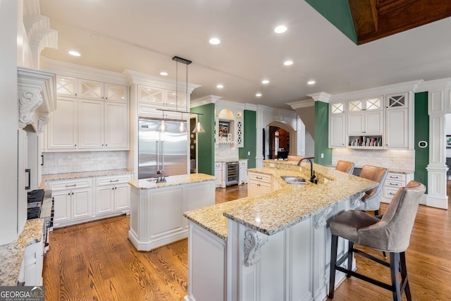 2855 Drayton Hall Dr, Buford, GA 30519 - kitchen with a sink, a large island with sink, stainless steel built in refrigerator, wine cooler, and backsplash