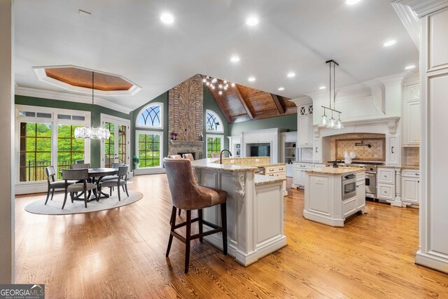 2855 Drayton Hall Dr, Buford, GA 30519 - kitchen with a fireplace, light wood finished floors, a spacious island, and high end range