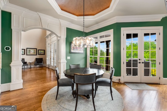 2855 Drayton Hall Dr, Buford, GA 30519 - dining area featuring a tray ceiling, french doors, an inviting chandelier, decorative columns, and light wood-type flooring