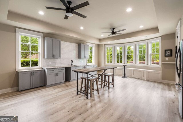 2855 Drayton Hall Dr, Buford, GA 30519 - kitchen featuring a tray ceiling, ceiling fan, light wood-style flooring, and gray cabinets