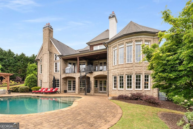 2855 Drayton Hall Dr, Buford, GA 30519 - rear view of house with a balcony, a chimney, french doors, an outdoor pool, and a patio area