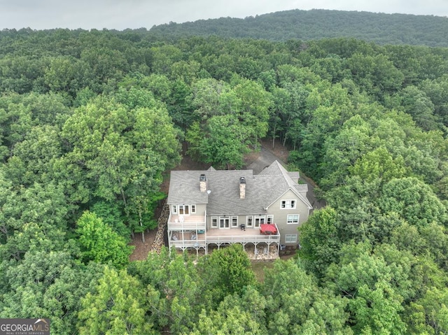 drone / aerial view featuring a wooded view