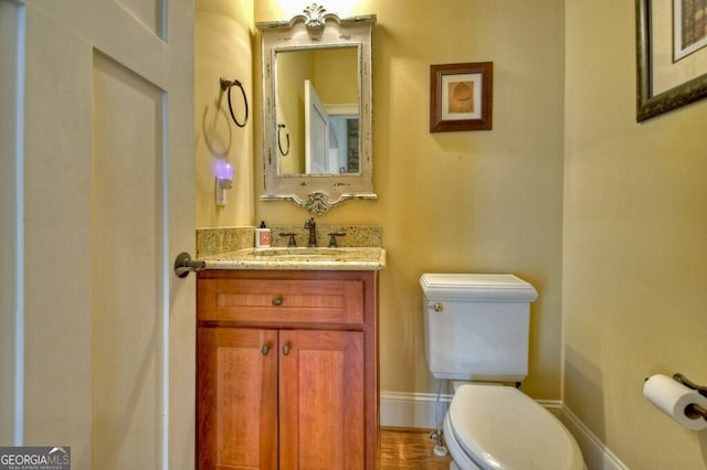 bathroom featuring vanity, baseboards, and toilet