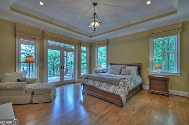 bedroom with french doors, ornamental molding, and a raised ceiling