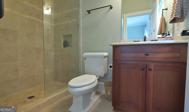 full bath featuring vanity, a tile shower, and toilet