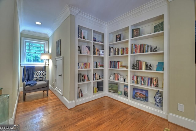 sitting room with baseboards, ornamental molding, and wood finished floors