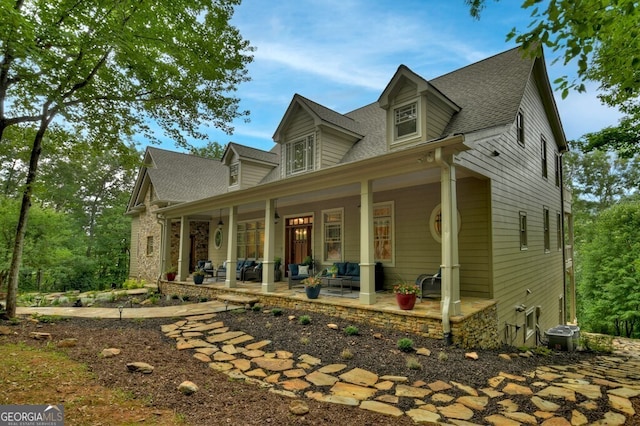 view of front of property with a porch, roof with shingles, and central air condition unit