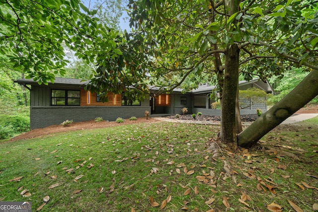 ranch-style house with board and batten siding and brick siding