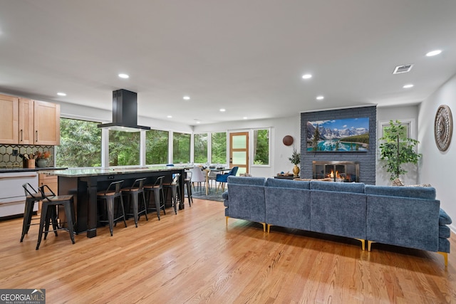 living area with recessed lighting, light wood-style floors, and a fireplace