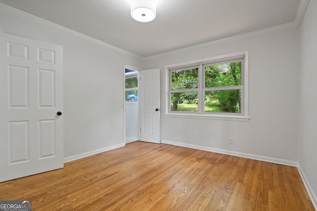unfurnished bedroom featuring baseboards, light wood-type flooring, and ornamental molding