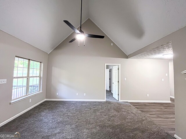 unfurnished room featuring baseboards, ceiling fan, high vaulted ceiling, and carpet floors