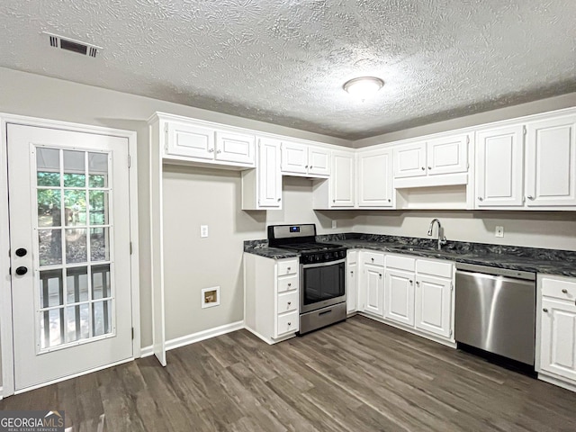 kitchen with a sink, appliances with stainless steel finishes, dark wood-style floors, and white cabinetry