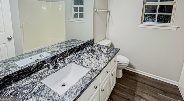 full bath with toilet, baseboards, wood finished floors, and vanity