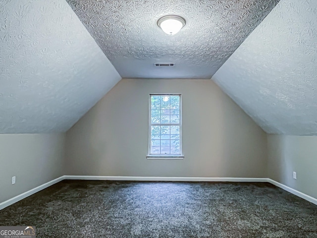bonus room featuring baseboards, vaulted ceiling, a textured ceiling, and visible vents