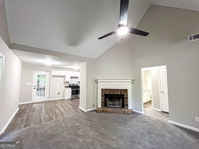 unfurnished living room featuring visible vents, wood finished floors, a fireplace, baseboards, and ceiling fan