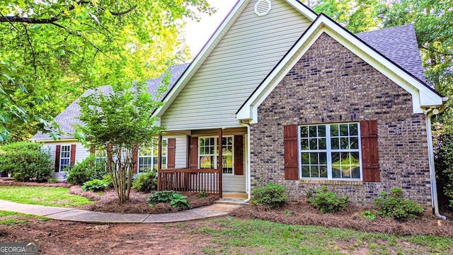 view of front facade featuring brick siding and covered porch