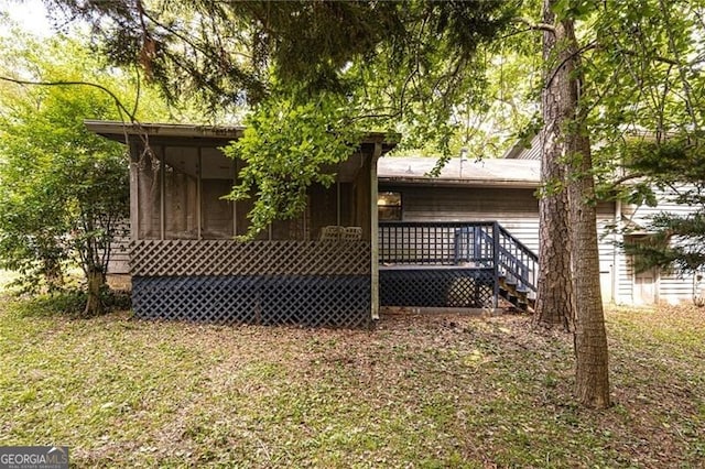 rear view of house with a sunroom and a deck