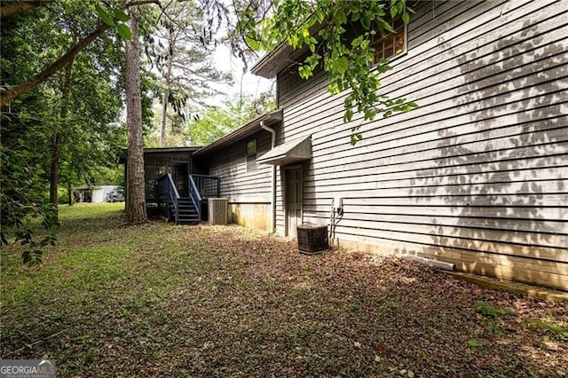 view of side of property featuring central AC and stairs