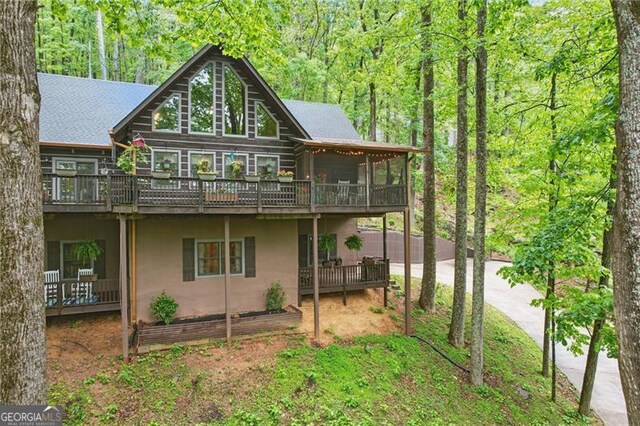 334 Little Pine Mountain Rd, Jasper, GA 30143 - back of house featuring driveway, a deck, a sunroom, a view of trees, and stucco siding