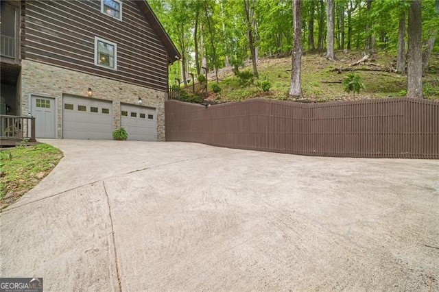 334 Little Pine Mountain Rd, Jasper, GA 30143 - view of side of home featuring a garage, stone siding, and concrete driveway