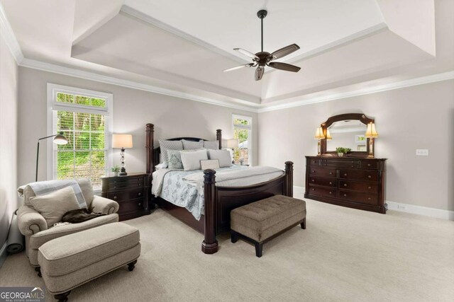 carpeted bedroom featuring crown molding, a ceiling fan, a raised ceiling, and baseboards