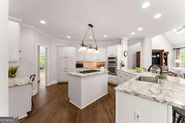 kitchen featuring dark wood-style flooring, a sink, white cabinetry, tasteful backsplash, and a kitchen island