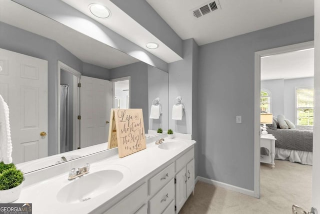 bathroom with visible vents, a sink, baseboards, and double vanity