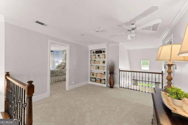 sitting room featuring crown molding, carpet, a ceiling fan, an upstairs landing, and visible vents