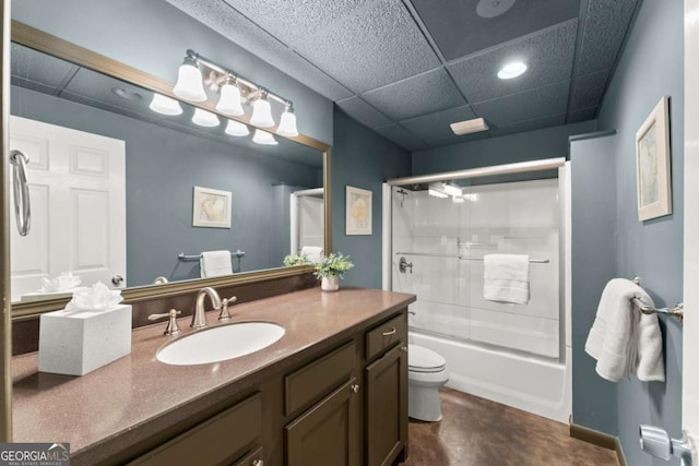 full bathroom with vanity, toilet, a paneled ceiling, finished concrete floors, and bath / shower combo with glass door