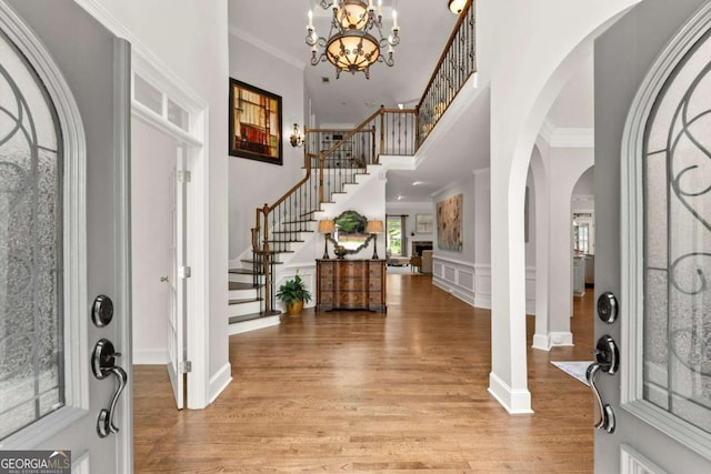 entryway with a wealth of natural light, light wood finished floors, and stairs