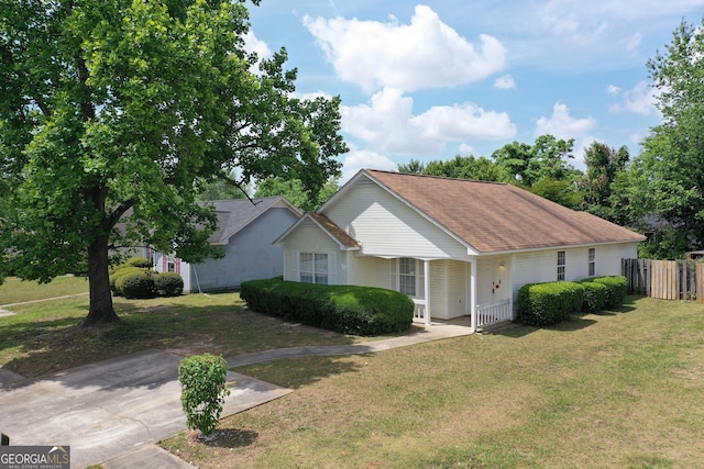 302 Kensington Cir, Warner Robins, GA 31093 - view of front facade with fence, covered porch, a shingled roof, and a front yard