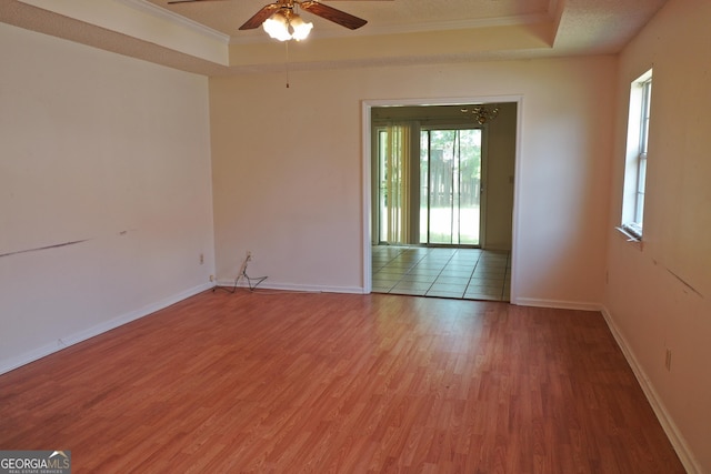 302 Kensington Cir, Warner Robins, GA 31093 - spare room featuring ceiling fan, light wood finished floors, baseboards, a tray ceiling, and ornamental molding