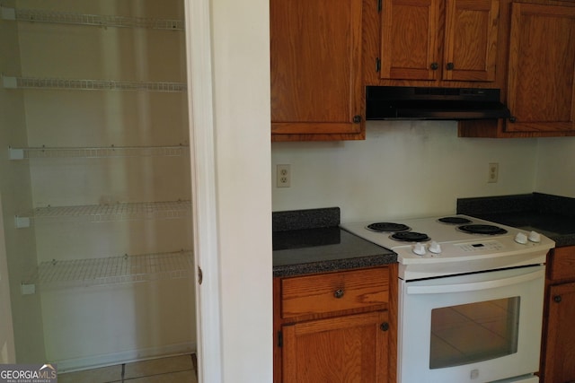 302 Kensington Cir, Warner Robins, GA 31093 - kitchen with under cabinet range hood, brown cabinets, white range with electric stovetop, and dark countertops