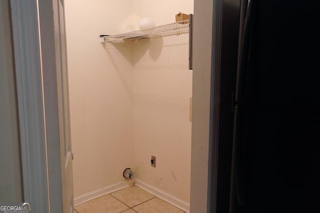 302 Kensington Cir, Warner Robins, GA 31093 - clothes washing area with baseboards, light tile patterned flooring, laundry area, and electric dryer hookup