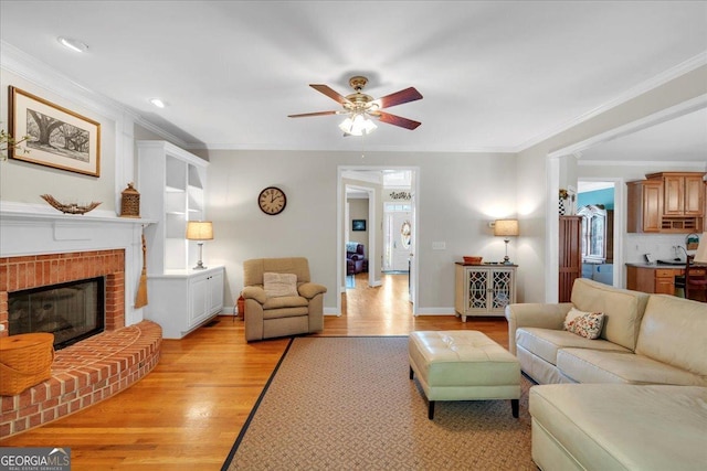 6034 Addington Dr NW, Acworth, GA 30101 - living area with crown molding, a fireplace, baseboards, ceiling fan, and light wood-style flooring
