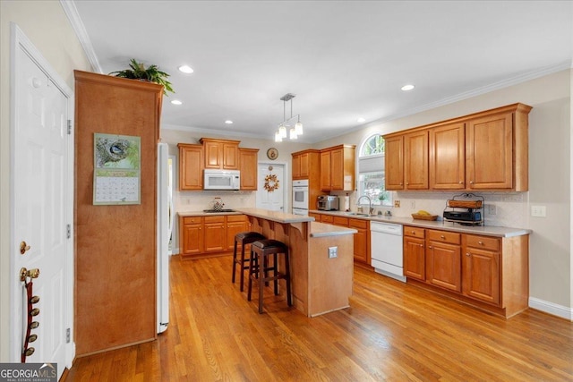 6034 Addington Dr NW, Acworth, GA 30101 - kitchen featuring a sink, white appliances, a kitchen breakfast bar, light countertops, and tasteful backsplash