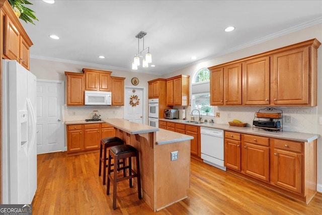 6034 Addington Dr NW, Acworth, GA 30101 - kitchen with tasteful backsplash, white appliances, light countertops, light wood-type flooring, and a kitchen bar