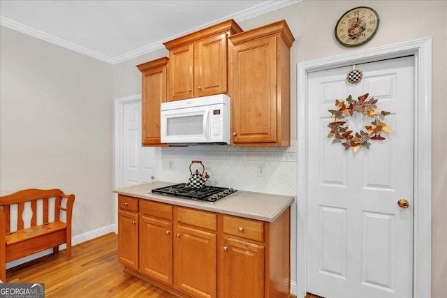 6034 Addington Dr NW, Acworth, GA 30101 - kitchen featuring decorative backsplash, stainless steel gas cooktop, light wood-type flooring, light countertops, and white microwave
