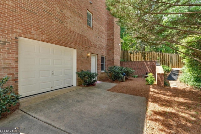 6034 Addington Dr NW, Acworth, GA 30101 - view of property exterior with concrete driveway, brick siding, an attached garage, and fence