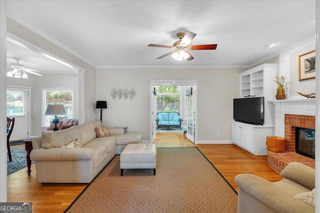 6034 Addington Dr NW, Acworth, GA 30101 - living area with crown molding, a ceiling fan, light wood-style flooring, and a fireplace