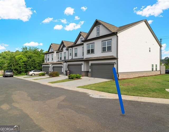 view of property featuring a garage, driveway, and a front yard