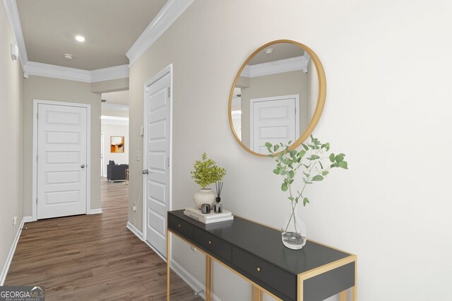 hallway with baseboards, ornamental molding, and wood finished floors