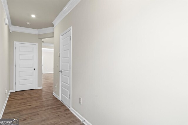 corridor featuring baseboards, ornamental molding, recessed lighting, and wood finished floors